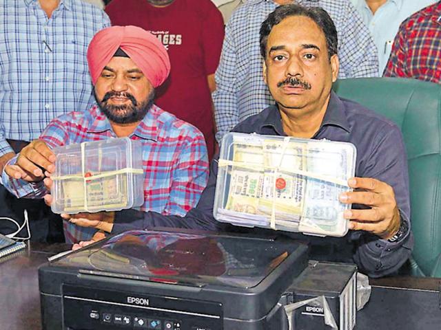 GP counter-intelligence MF Farooqui and other officers displaying recovered fake currency and printer during a conference in Amritsar on Wednesday.(Gurpreet Singh/HT Photo)