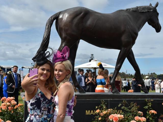 Racegoers pose for a selfie in front of the Makybe Diva statue at Flemington Racecourse in Melbourne. Makybe Diva is the British-bred, Australian-trained Thoroughbred racehorse who became the first horse to win the Melbourne Cup thrice. (AFP) Racegoers pose for a selfie in front of the Makybe Diva statue at Flemington Racecourse in Melbourne. Makybe Diva is the British-bred, Australian-trained Thoroughbred racehorse who became the first horse to win the Melbourne Cup thrice. (AFP)