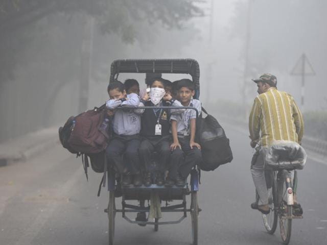 Students cover faces as heavy smog covers capital’s skyline, in Mayur Vihar in New Delhi.(Sushil Kumar/HT Photo)