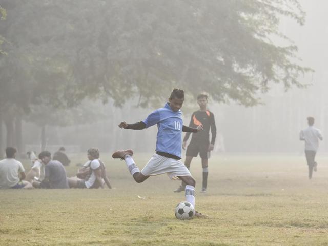 Youngsters play soccer at Sanjay Lake in New Delhi, on November 4, 2016. Despite the thick smog, locals have continued with their outdoor activities, such as taking walks in the park. But experts warn against stepping out during the early hours and late hours of the day -- this is when pollution levels are higher. (Raj K Raj/HT PHOTO) Youngsters play soccer at Sanjay Lake in New Delhi, on November 4, 2016. Despite the thick smog, locals have continued with their outdoor activities, such as taking walks in the park. But experts warn against stepping out during the early hours and late hours of the day -- this is when pollution levels are higher. (Raj K Raj/HT PHOTO)