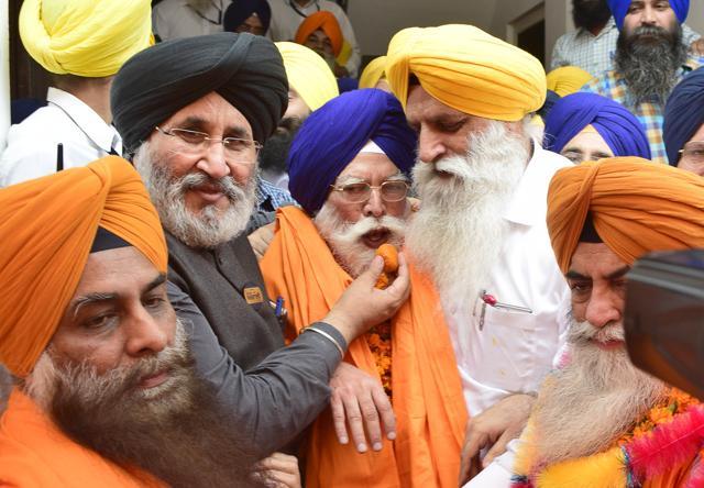 Daljit Singh Cheema, SAD spokesman and Punjab education minister, offering sweets to Badungar. (Gurpreet Singh/HT Photo)