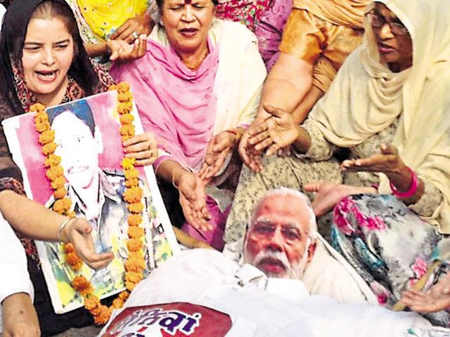 District Mahila Congress workers burning an effigy of Prime Minister Narendra Modi during a protest at Hall Gate in Amritsar on Friday. (HT Photo) District Mahila Congress workers burning an effigy of Prime Minister Narendra Modi during a protest at Hall Gate in Amritsar on Friday. (HT Photo)