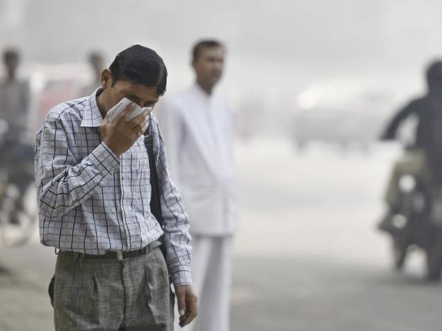 School children cover their noses with cloth as they navigate Delhi roads on their way to school on a smog-filled Friday morning.(Raj K Raj/HT Photo)
