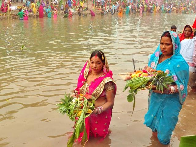 Devotees worship the setting sun at Sirhind canal in Bathinda on Sunday. (Sanjeev Kumar/HT Photo)