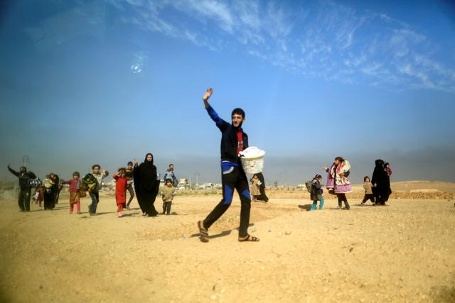 People who are fleeing the fighting between Islamic State and Iraqi army are pictured through a car window as they walk in the desert near the front line in the Intisar disrict of eastern Mosul, Iraq, November 6, 2016. (REUTERS) People who are fleeing the fighting between Islamic State and Iraqi army are pictured through a car window as they walk in the desert near the front line in the Intisar disrict of eastern Mosul, Iraq, November 6, 2016. (REUTERS)
