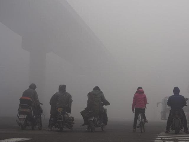 Residents on their bicycles and electric bikes wait for the traffic at an intersection amid heavy smog in Shijiazhuang, Hebei province, China, December 10, 2015. (Reuters) Residents on their bicycles and electric bikes wait for the traffic at an intersection amid heavy smog in Shijiazhuang, Hebei province, China, December 10, 2015. (Reuters)