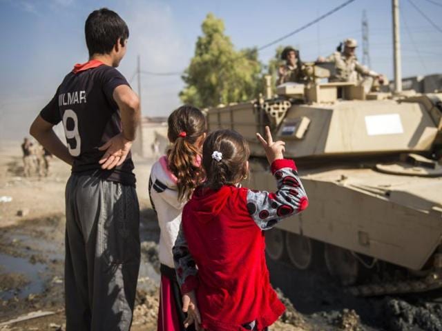 Iraqi children, one flashing the sign of victory, greet Iraqi army's soldiers from the 9th armoured division in the area of Ali Rash, adjacent to the eastern Al-Intissar neighbourhood of Mosul, on November 6, 2016, during a military operation to retake the main hub city from the Islamic State (IS) group jihadists.(AFP) Iraqi children, one flashing the sign of victory, greet Iraqi army's soldiers from the 9th armoured division in the area of Ali Rash, adjacent to the eastern Al-Intissar neighbourhood of Mosul, on November 6, 2016, during a military operation to retake the main hub city from the Islamic State (IS) group jihadists.(AFP)