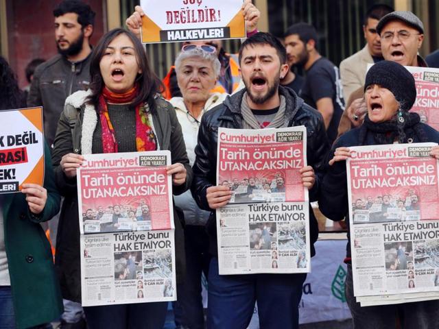 Protesters hold copies of the latest edition of the Turkish daily newspaper "Cumhuriyet" during a demonstration outside the newspaper's headquarters in Ankara on Saturday. (AFP Photo) Protesters hold copies of the latest edition of the Turkish daily newspaper "Cumhuriyet" during a demonstration outside the newspaper's headquarters in Ankara on Saturday. (AFP Photo)