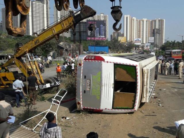 People bring out things from the bus after it toppled over.(Praful Gangurde/HT Photo)