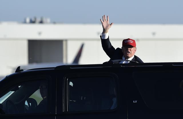 Republican presidential nominee Donald Trump waves to supporter who were waiting outside of the fence following a rally at the Sun Country Airlines hangar in Minneapolis, Minnesota on November 6, 2016. (AFP) Republican presidential nominee Donald Trump waves to supporter who were waiting outside of the fence following a rally at the Sun Country Airlines hangar in Minneapolis, Minnesota on November 6, 2016. (AFP)