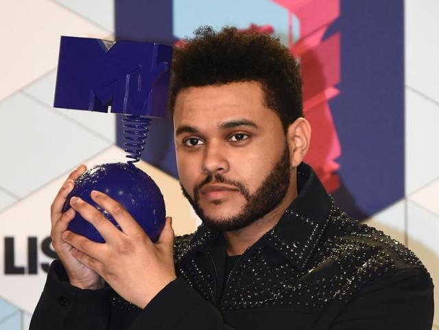 The Weeknd rocked his short new hair and that award he just got. (AFP) The Weeknd rocked his short new hair and that award he just got. (AFP)