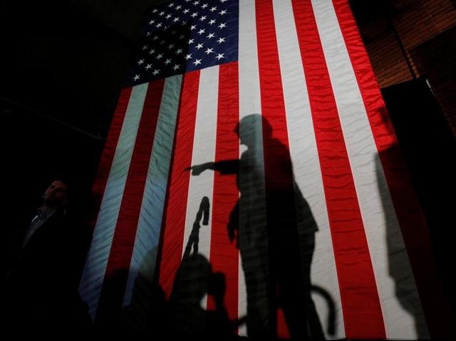US Democratic presidential nominee Hillary Clinton was caught in a controversy in March 2015 over her use of a private email server for official correspondence while she was serving as Secretary of the State. Here she casts a shadow on a US flag at the conclusion of a campaign rally in Manchester on November 6, 2016. (REUTERS Photo)