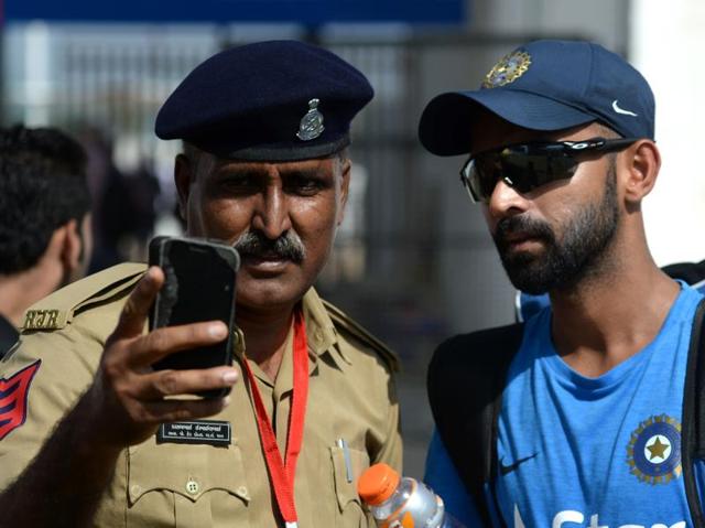 India's Ajinkya Rahane poses for a 'selfie' with a policeman while walking back after a training on Tuesday. (AFP)