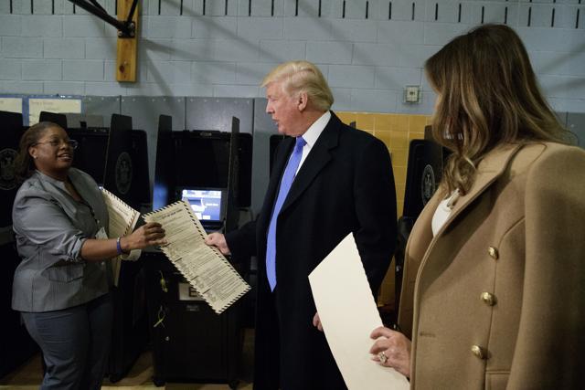 Republican presidential candidate Donald Trump, with his wife Melania, right, hands over his ballot to an election worker after voting at PS-59. (AP Photo) Republican presidential candidate Donald Trump, with his wife Melania, right, hands over his ballot to an election worker after voting at PS-59. (AP Photo)