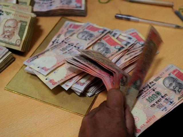 A bank employee counts Indian rupee notes at a bank in Mumbai on May 16, 2012.(AFP)