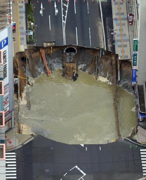 By mid-morning an entire section of a main road had caved in and the 20 metre-wide hole had started to fill with water. (AP Photo)