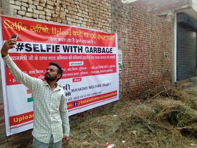 A man taking a selfie with garbage on Ferozepur road in Ludhiana on Monday.(HT Photo) A man taking a selfie with garbage on Ferozepur road in Ludhiana on Monday.(HT Photo)