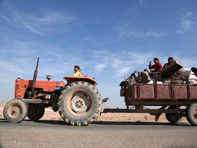 People fleeing areas of conflict ride a vehicle, north of Raqqa city. (REUTERS Photo)