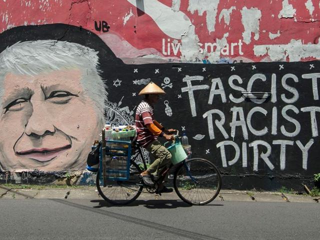 Republican Presidential nominee Donald Trump has been openly criticised for tweeting quite liberally and, often, offensively. Here a man cycles past graffiti condemning Donald Trump, on a street in Surabaya, Indonesia's east Java on October 17, 2016. (AFP Photo)