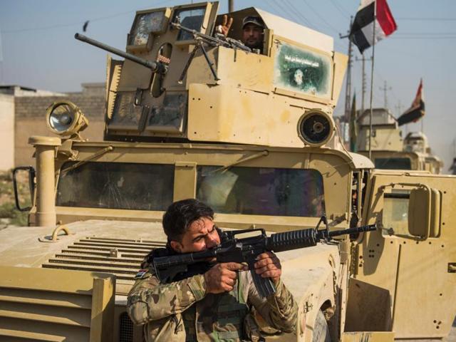 A soldier from the Iraqi army's 9th armoured division aims his weapon as they move around the Al-Intissar neighbourhood of Mosul on November 7.(AFP)