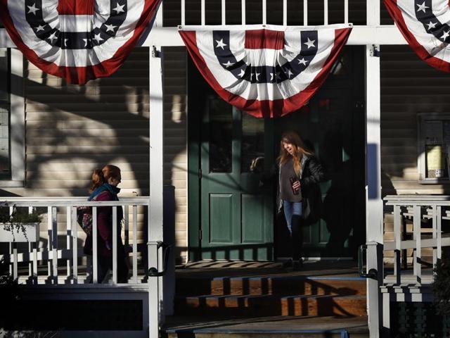 Amanda Pacilli, 29, holds the door open for a fellow voter arriving at the town hall. "I'm so relieved that Election Day is finally here," said Pacilli. "I'm just happy to see other people involved in voting." (AP) Amanda Pacilli, 29, holds the door open for a fellow voter arriving at the town hall. "I'm so relieved that Election Day is finally here," said Pacilli. "I'm just happy to see other people involved in voting." (AP)