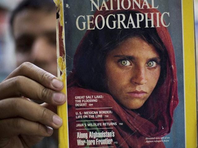 Pakistan's Inam Khan, owner of a book shop shows a copy of a magazine with the photograph of Afghan refugee woman Sharbat Gulla, from his rare collection in Islamabad, Pakistan, on October 26.(AP) Pakistan's Inam Khan, owner of a book shop shows a copy of a magazine with the photograph of Afghan refugee woman Sharbat Gulla, from his rare collection in Islamabad, Pakistan, on October 26.(AP)