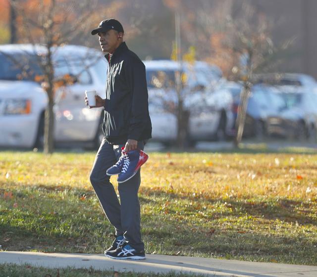 President Barack Obama carries a pair of sneakers as he arrives for a private game of basketball at Fort McNair in Washington. (AP)