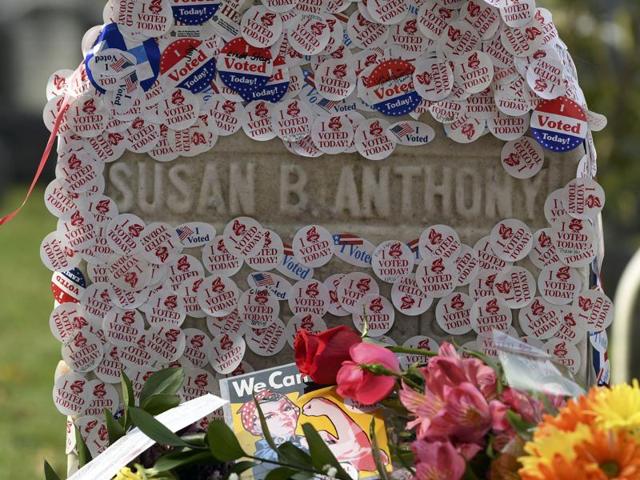 Visitors pose next to the grave of women's suffrage leader Susan B. Anthony, covered with "I Voted" stickers left by voters at Mount Hope Cemetery in Rochester.(REUTERS)