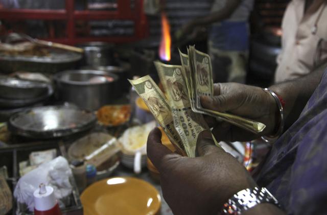 A man refuses to take 500 rupees from a customer in New Delhi following Prime Minister Narendra Modi’s announcement scrapping high denomination 500 and 1,000 Indian rupees currency notes in what he describes as a major step to fight the menace of black money, corruption and fake currency.(AP) A man refuses to take 500 rupees from a customer in New Delhi following Prime Minister Narendra Modi’s announcement scrapping high denomination 500 and 1,000 Indian rupees currency notes in what he describes as a major step to fight the menace of black money, corruption and fake currency.(AP)