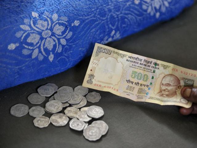 A resident hands a 500 Rupee note to a money lender at his shop in Hyderabad on November 9. (AFP) A resident hands a 500 Rupee note to a money lender at his shop in Hyderabad on November 9. (AFP)