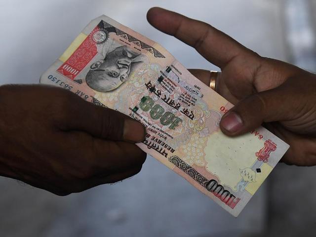 An Indian vehicle driver gives a 1000 rupee note to the Toll Plaza employee at the Nivedita Setu Toll plaza at Rajchandrapur on the outskirts of Kolkata.(AFP Photo)