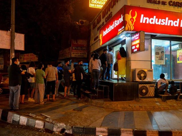 People queue to try to withdraw money from an ATM in New Delhi.(AFP)