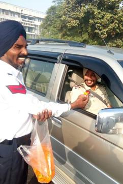 A traffic police cop offering a flower to another cop for obeying traffic rules. (HT Photo)