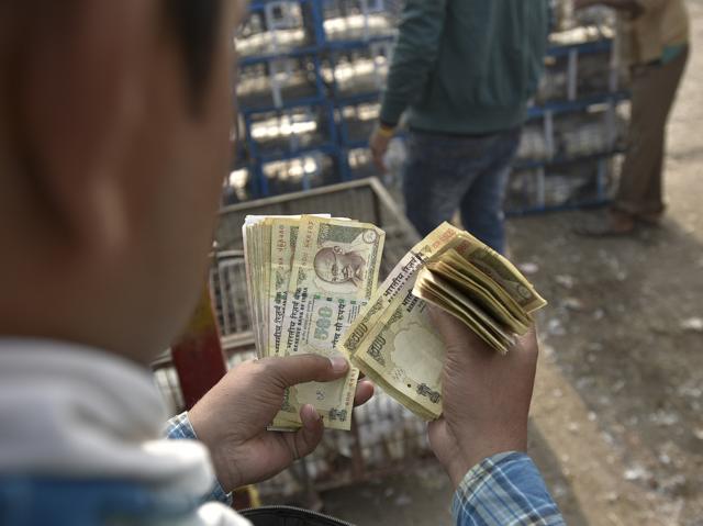 A man holds Rs.500 and Rs.1000 currency notes at Ghazipur chicken market in New Delhi.(Ravi Choudhary/HT PHOTO)