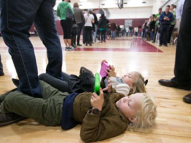 Merrick, 4, (front) and Savannah Little, 5, entertain themselves with electronic devices while waiting in line with their parents on election day November 8, 2016 at Grady High School in Atlanta, Georgia. After a contentious campaign season, Americans go to the polls today to choose the next president of the United States. (AFP) Merrick, 4, (front) and Savannah Little, 5, entertain themselves with electronic devices while waiting in line with their parents on election day November 8, 2016 at Grady High School in Atlanta, Georgia. After a contentious campaign season, Americans go to the polls today to choose the next president of the United States. (AFP)