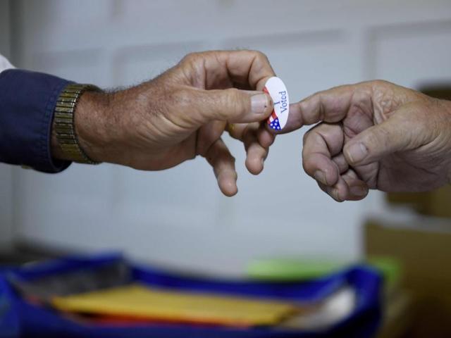 A poll volunteer hands out an 'I Voted' sticker at a rural polling place during the U.S. presidential election in Stillwater, Oklahoma, U.S. November 8, 2016. REUTERS/Nick Oxford (REUTERS) A poll volunteer hands out an 'I Voted' sticker at a rural polling place during the U.S. presidential election in Stillwater, Oklahoma, U.S. November 8, 2016. REUTERS/Nick Oxford (REUTERS)