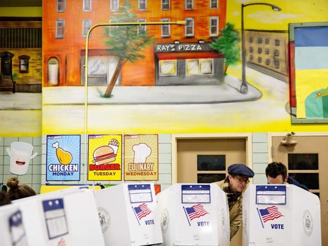 Peter McGough, left, talks with Adam Scheffer as they vote in a school cafeteria in New York. "We need to come together on all these issues and get to know each other," said McGough. "It's the separation that's killing us." (AP) Peter McGough, left, talks with Adam Scheffer as they vote in a school cafeteria in New York. "We need to come together on all these issues and get to know each other," said McGough. "It's the separation that's killing us." (AP)