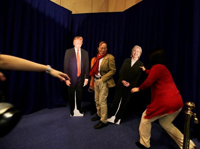 People pose with cardboard cutouts of presidential nominees Hillary Clinton and Donald Trump at an event held at the US embassy in Beijing on Wednesday.(Reuters)