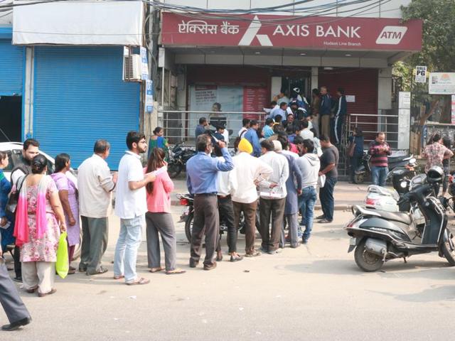 Watchmen are having a hard time dealing with students who queue up outside the ATMs and banks.(Nikita Saxena/HT Photo)