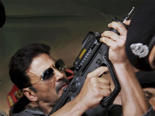 Akshay Kumar inspects a firearm during a visit to BSF's Paloura camp in Jammu. (PTI Photo)