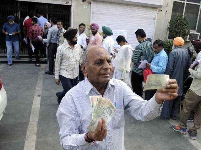 A man showing the Rs 100 notes after coming out of the bank in Patiala on Thursday. (Bharat Bhushan/HT Photo) A man showing the Rs 100 notes after coming out of the bank in Patiala on Thursday. (Bharat Bhushan/HT Photo)