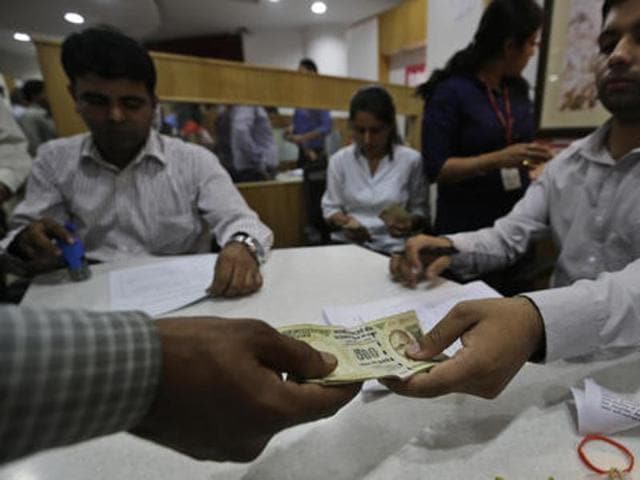 A man gives discontinued currency notes to exchange them with newly introduced currency notes a bank in New Delhi on Thursday.(AP Photo)