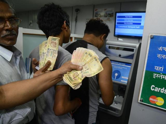 People queue to deposit money in a Cash Deposit Kiosk in Siliguri. Prime Minister Narendra Modi announced late November 8 that 500 and 1,000 rupee notes will be withdrawn from financial circulation from midnight, in a bid to tackle corruption.(AFP) People queue to deposit money in a Cash Deposit Kiosk in Siliguri. Prime Minister Narendra Modi announced late November 8 that 500 and 1,000 rupee notes will be withdrawn from financial circulation from midnight, in a bid to tackle corruption.(AFP)