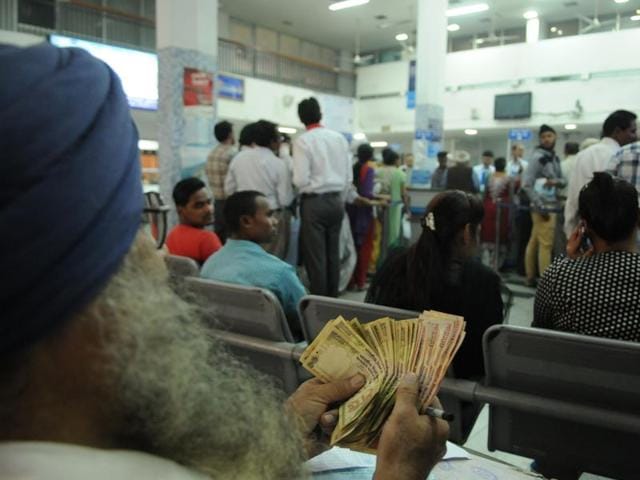 A customer counting currency notes before exchanging them in a bank at Jalandhar on Thursday. (Pardeep Pandit/HT Photo) 