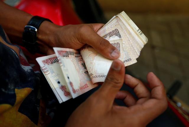 A man counts 500 and 1000 rupee banknotes outside a branch of Bank of India in Mumbai. (Reuters Photo) A man counts 500 and 1000 rupee banknotes outside a branch of Bank of India in Mumbai. (Reuters Photo)