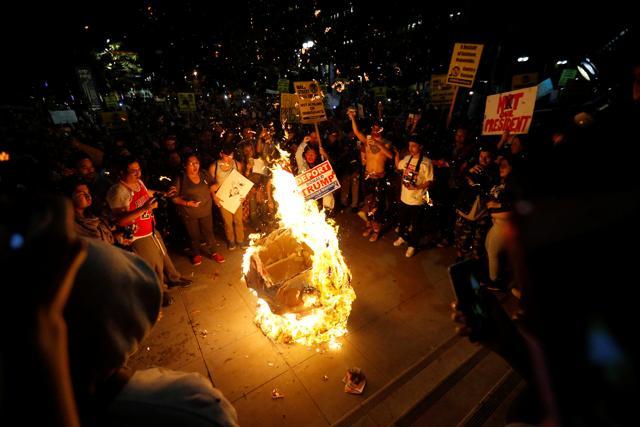 A Donald Trump effigy is burned by people protesting the election of Republican Donald Trump as the president of the United States in downtown Los Angeles on Wednesday. (Reuters) A Donald Trump effigy is burned by people protesting the election of Republican Donald Trump as the president of the United States in downtown Los Angeles on Wednesday. (Reuters)
