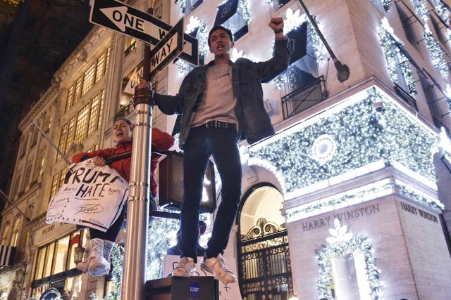 Protestors on a signpost shout slogans during a demonstration on 5th Avenue near Trump Tower on November 9, 2016 in New York. (AFP) Protestors on a signpost shout slogans during a demonstration on 5th Avenue near Trump Tower on November 9, 2016 in New York. (AFP)