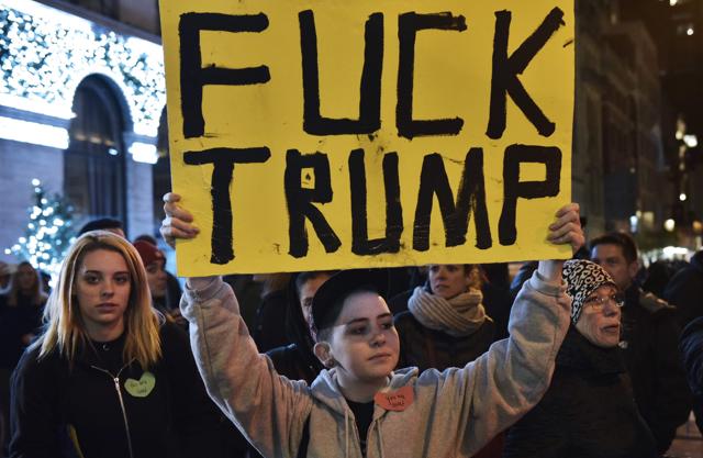 A protestor holds a placard during in a demonstration on 5th Avenue across from Trump Tower on November 9, 2016 in New York. (AFP) A protestor holds a placard during in a demonstration on 5th Avenue across from Trump Tower on November 9, 2016 in New York. (AFP)