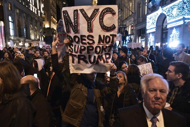 A protestor holds a placard during in a demonstration on 5th Avenue across from Trump Tower on November 9, 2016 in New York. (AFP) A protestor holds a placard during in a demonstration on 5th Avenue across from Trump Tower on November 9, 2016 in New York. (AFP)