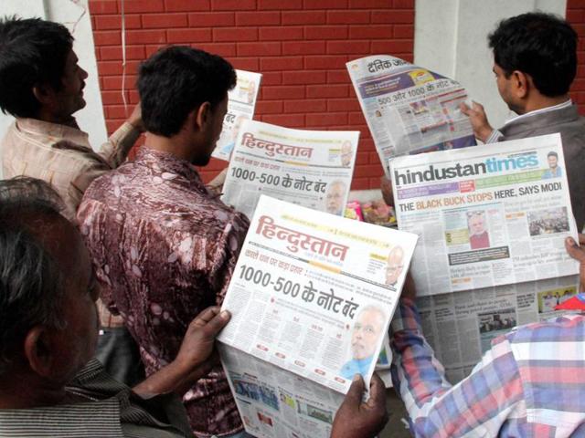 People read newspapers the day after Prime Minister Narendra Modi ordered to ban Rs 500 and Rs 1000 notes, in Allahabad on Wednesday.(PTI)